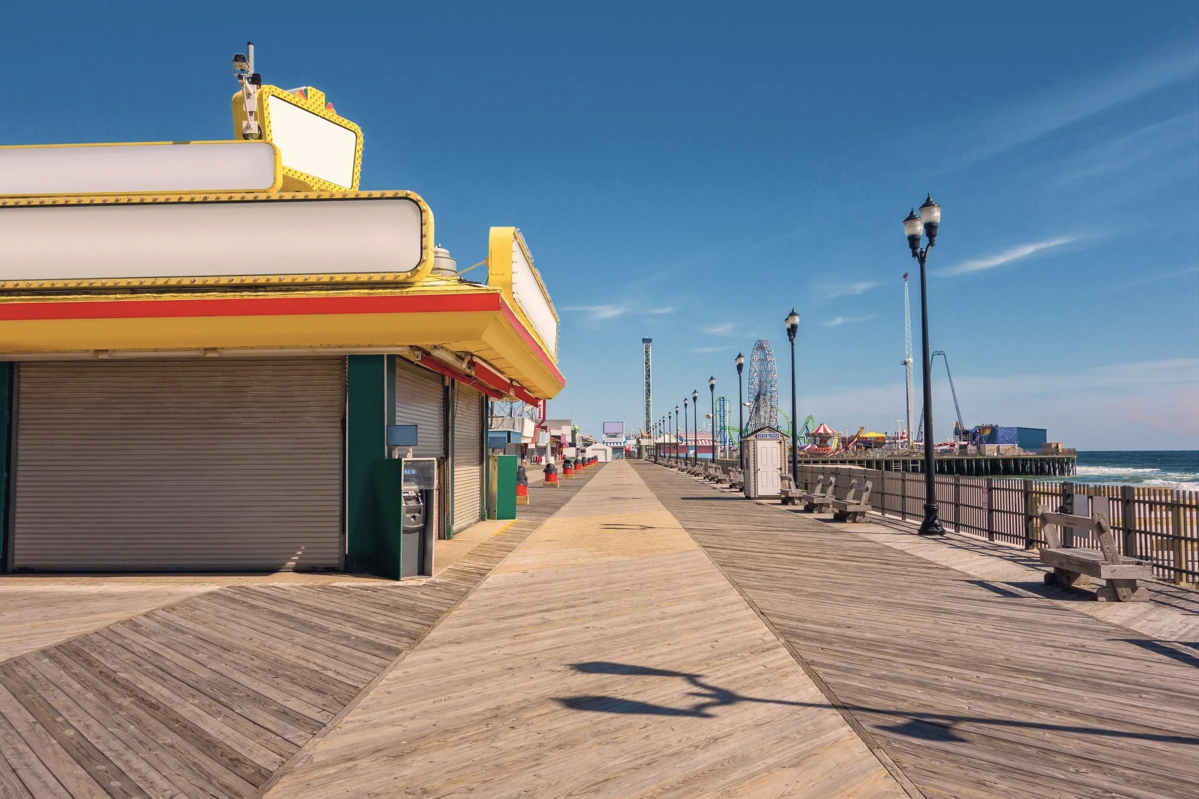 The boardwalk on a sunny day, with Steel Pier's Ferris wheel in the distance